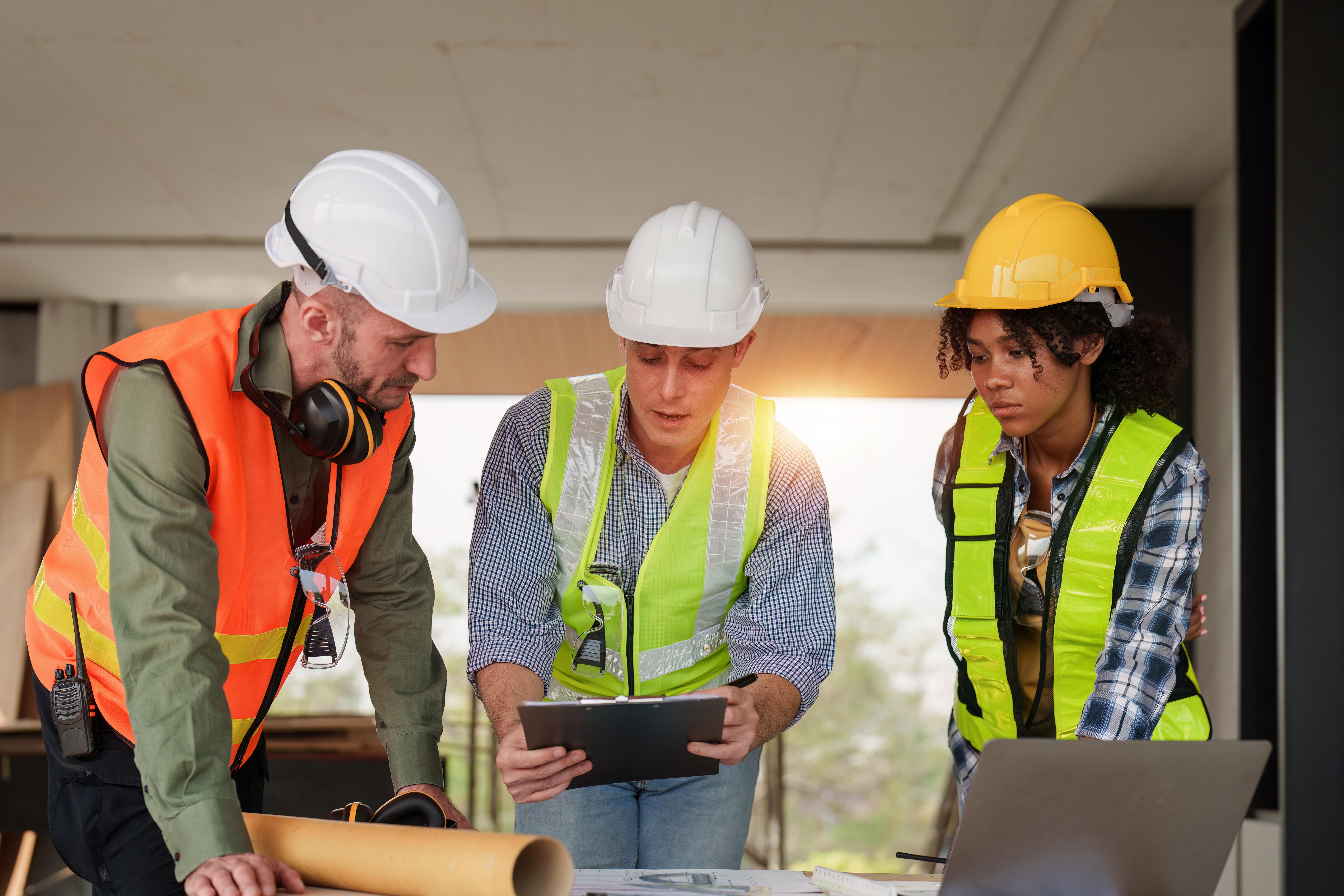 Architect team working with blueprints for architectural plan, engineer sketching a construction project